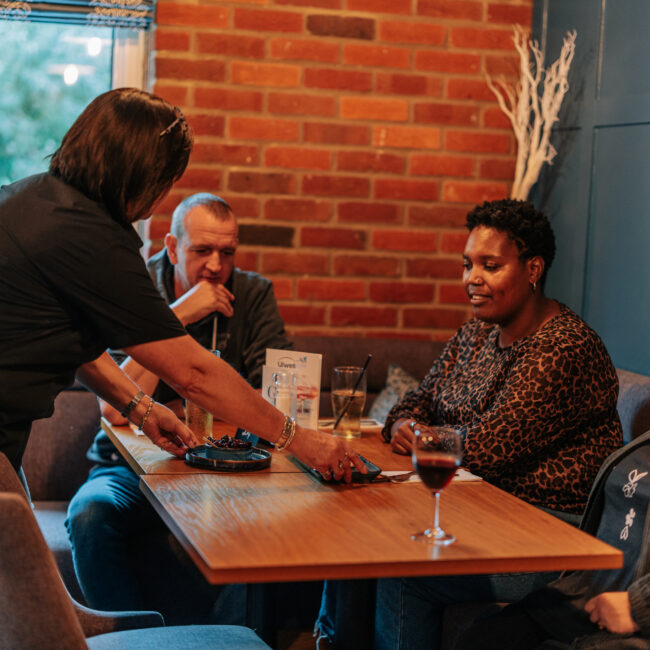 waitress serving a group of friends at the village inn